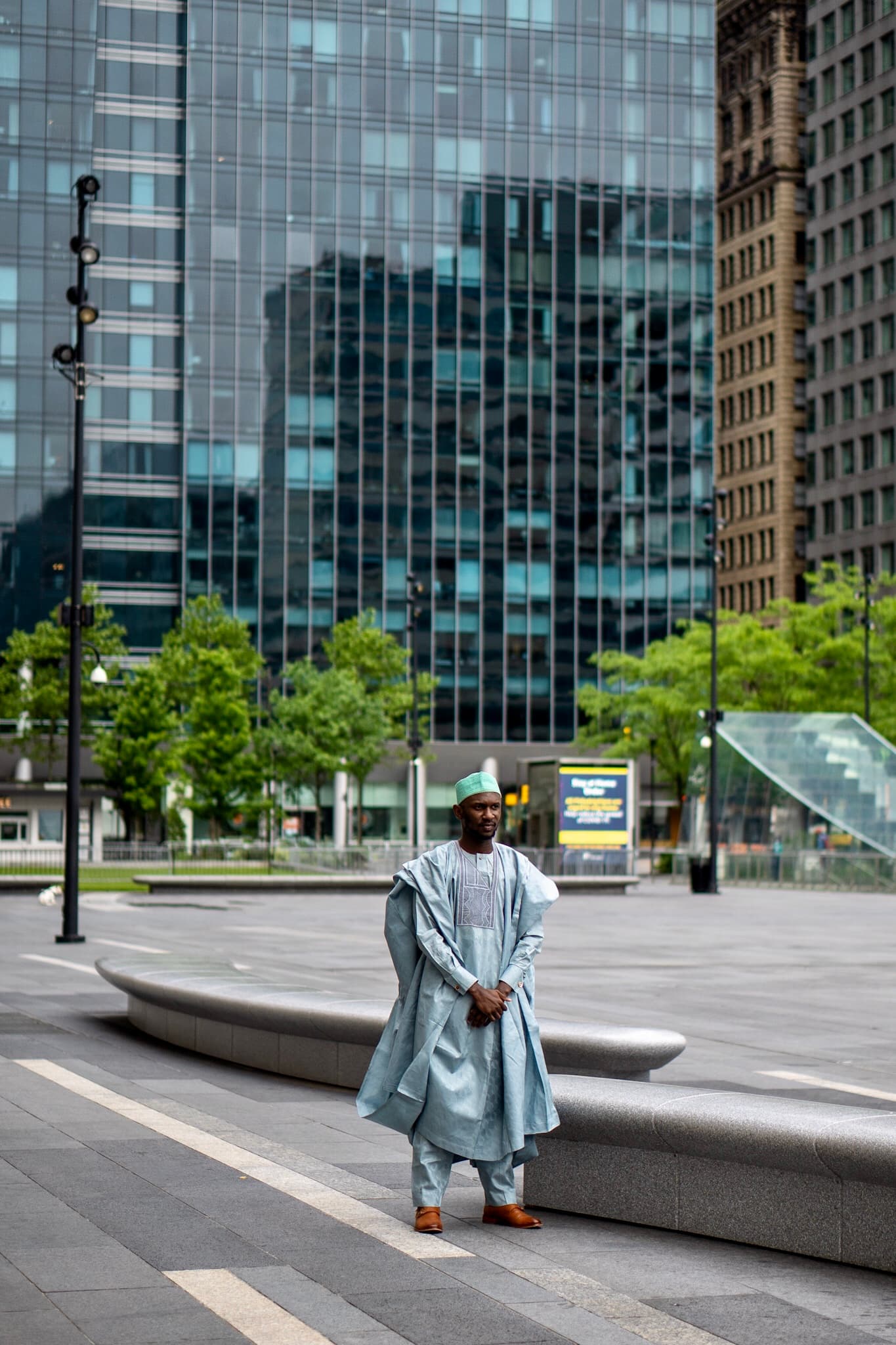Portrait, man in light blue agbada, city plaza, full length