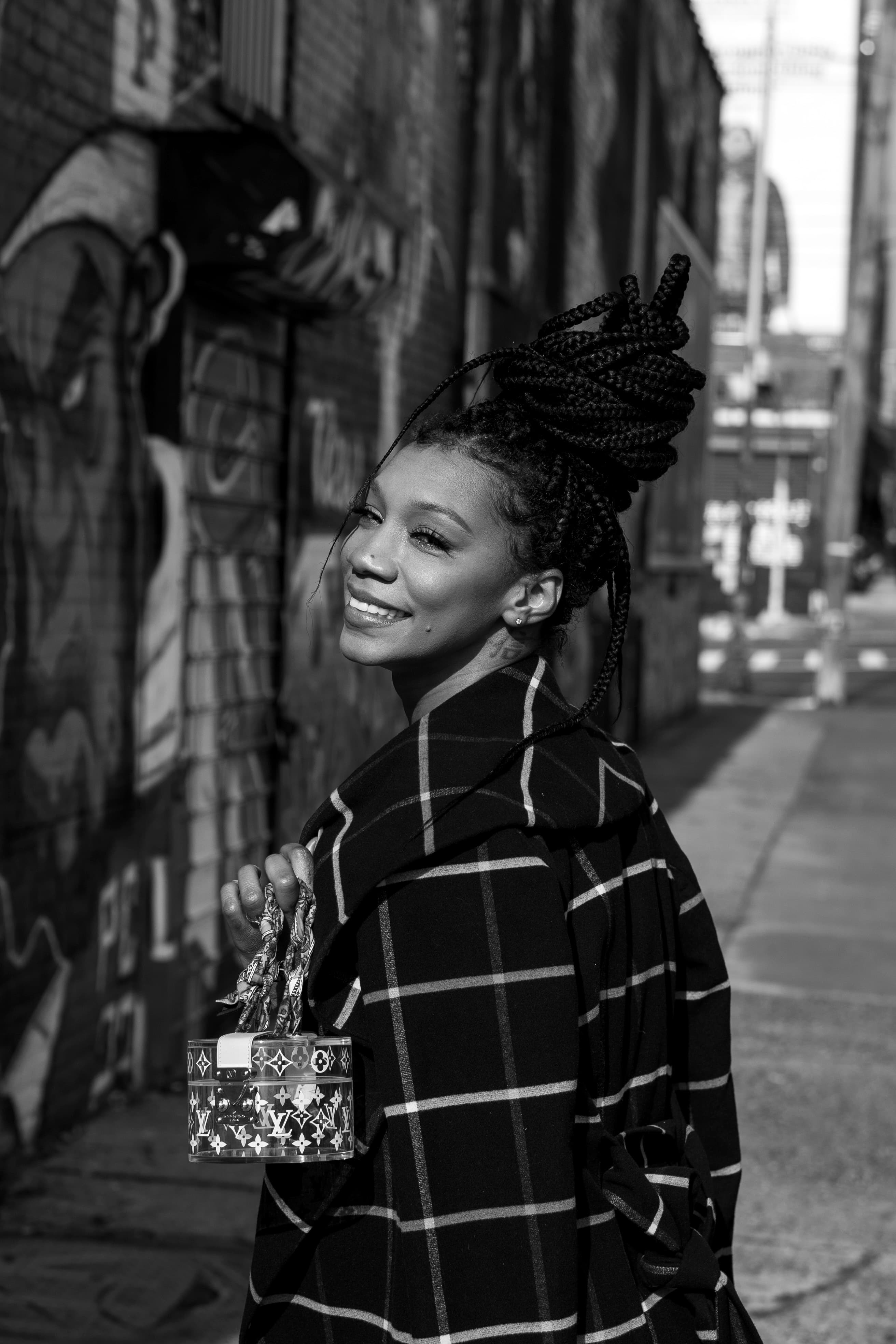 Street editorial, woman in plaid coat with LV bag, alley backdrop