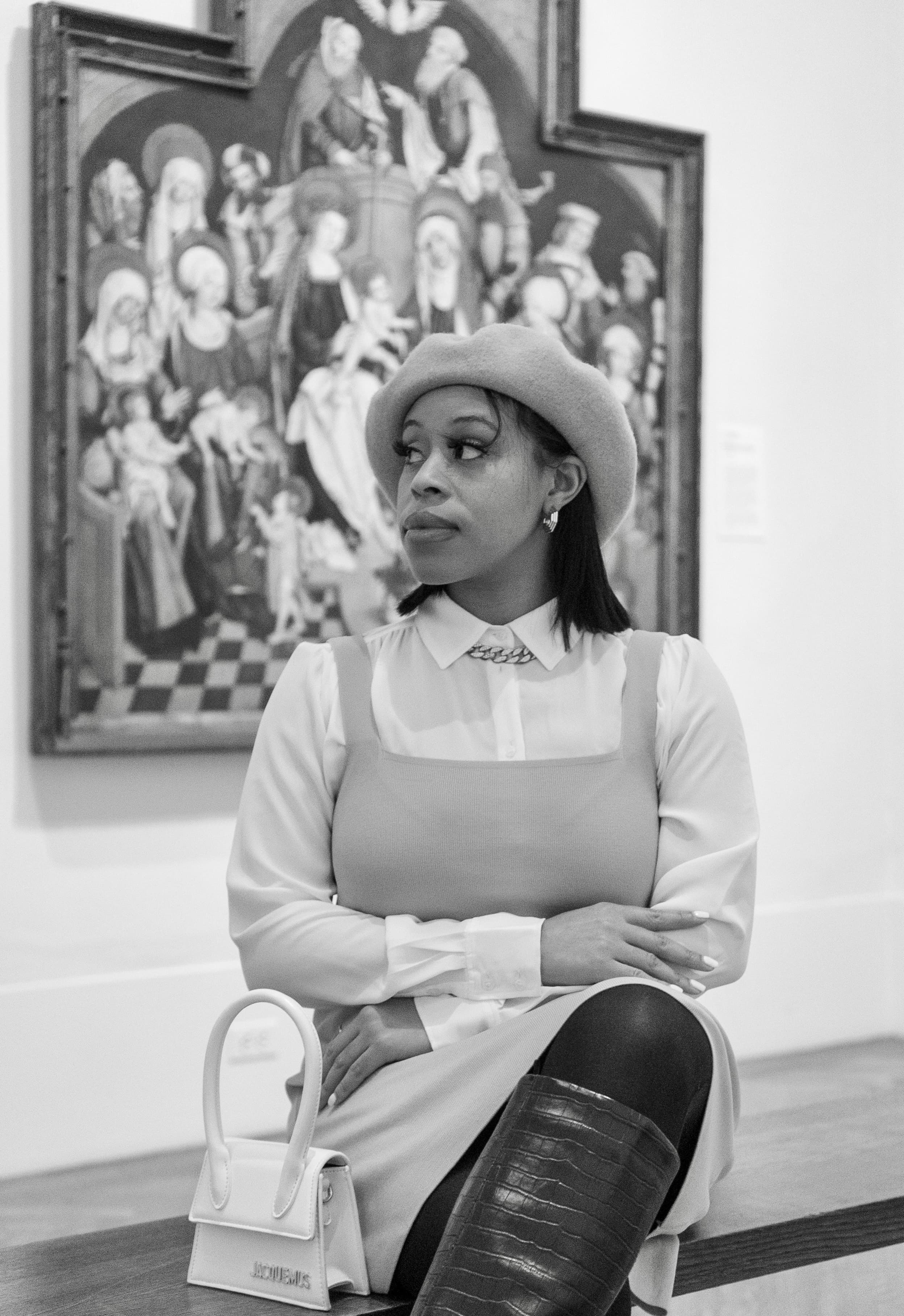 Monochrome editorial, woman in beret seated at museum
