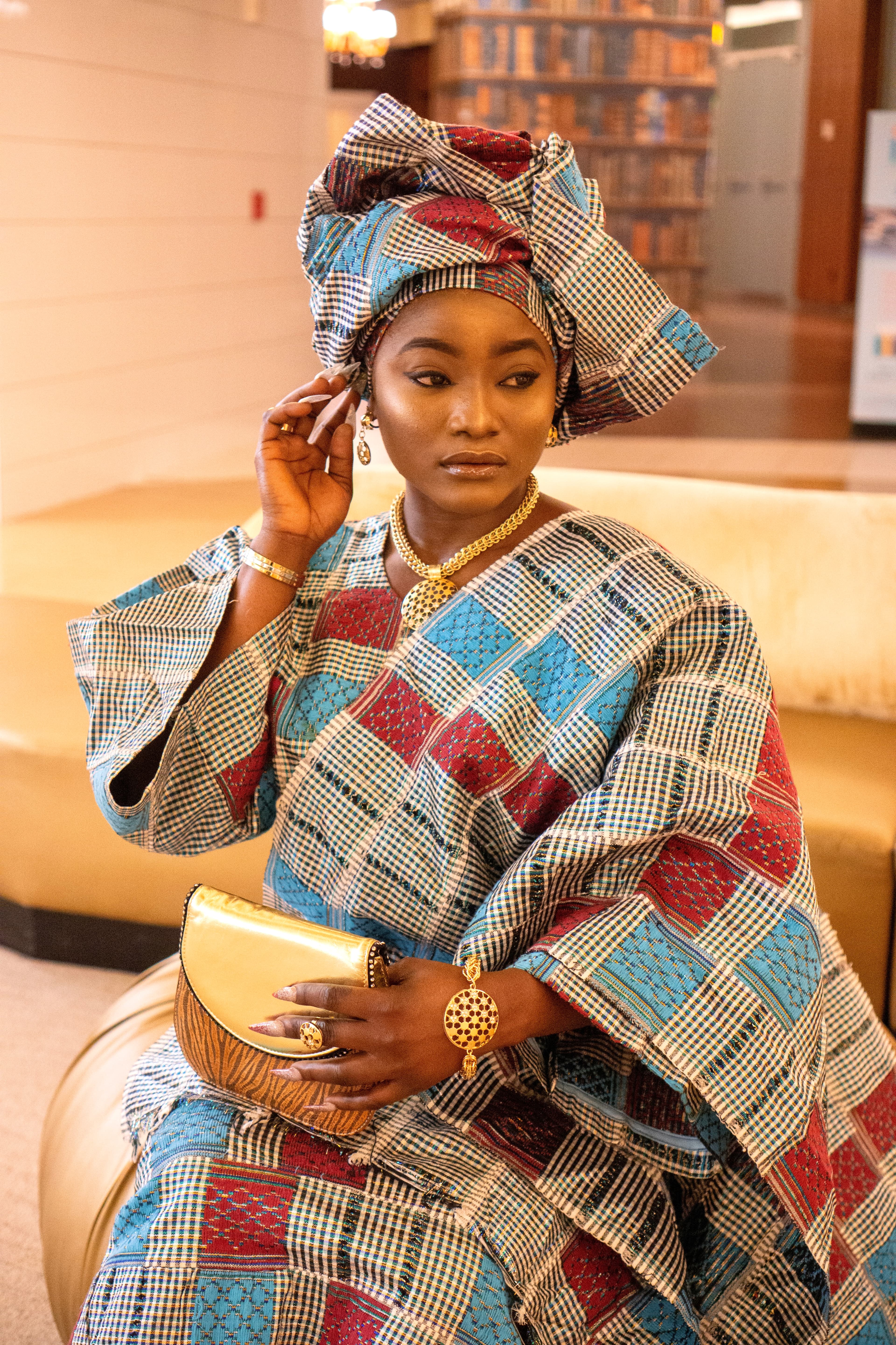 Close-up editorial portrait, woman in African print with gold jewelry
