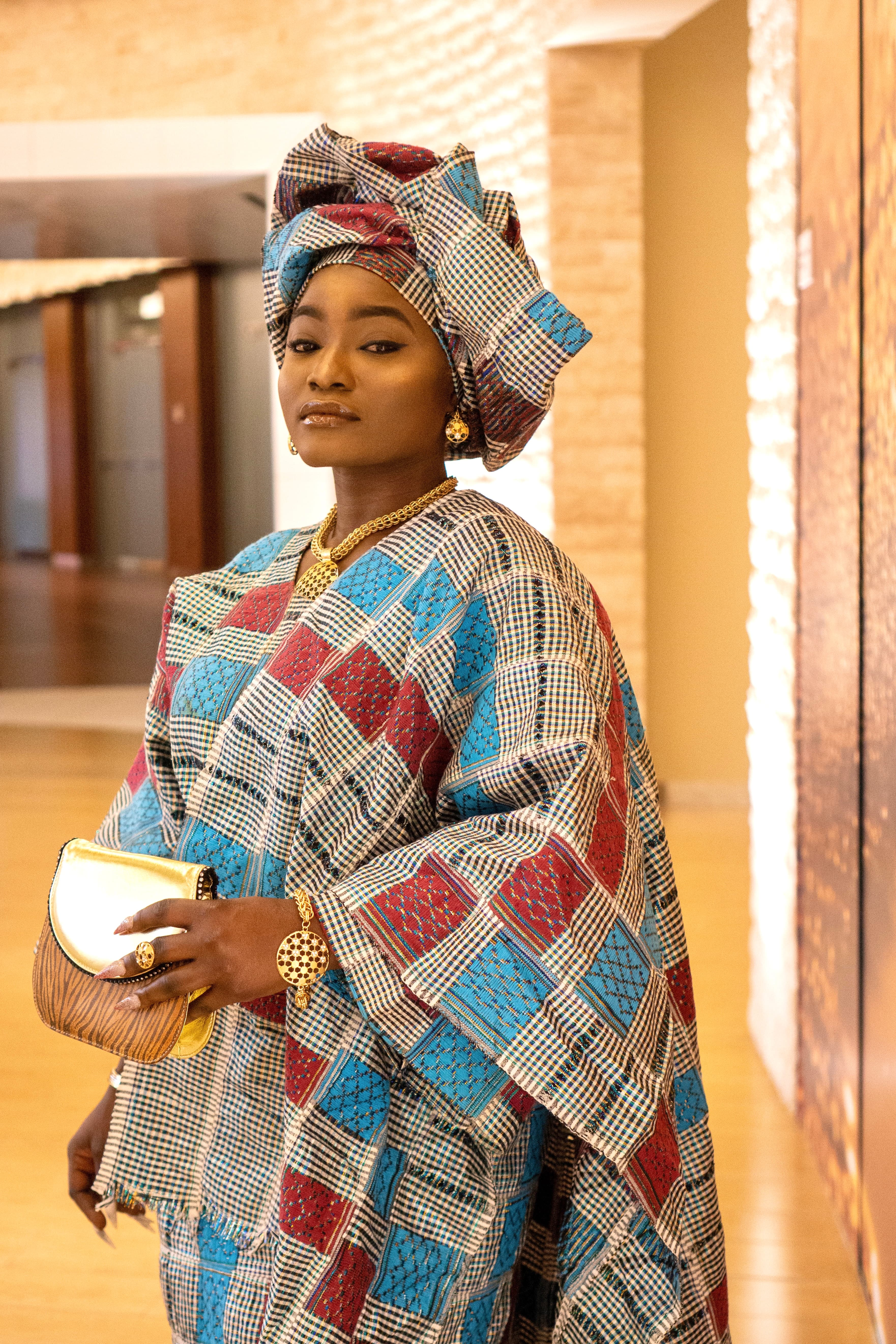 Portrait, woman in African print standing in lobby corridor