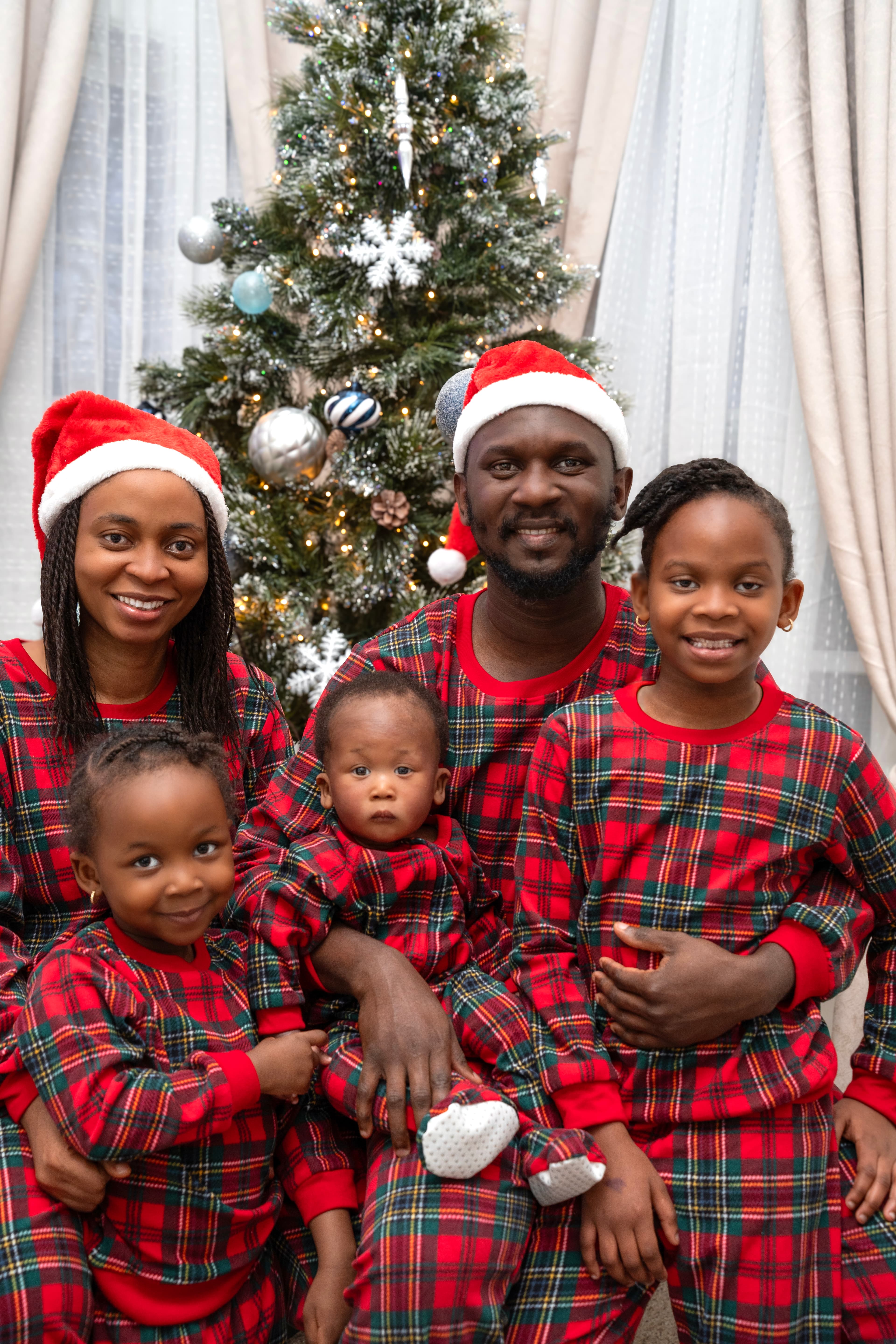Family Christmas portrait, parents and children by tree